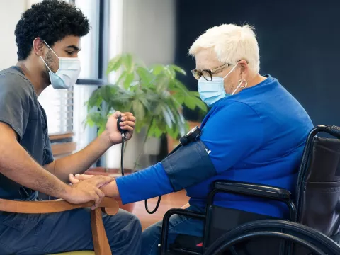 A health care professional checks a woman's blood pressure.