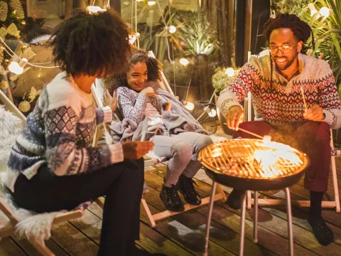 A family roasting marshmallows outside.