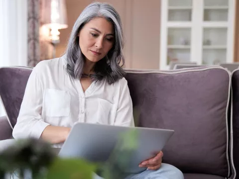 A woman indoors and on her laptop