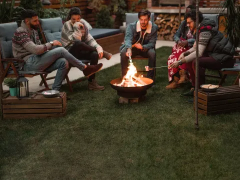 Friends making s'mores over a fire pit