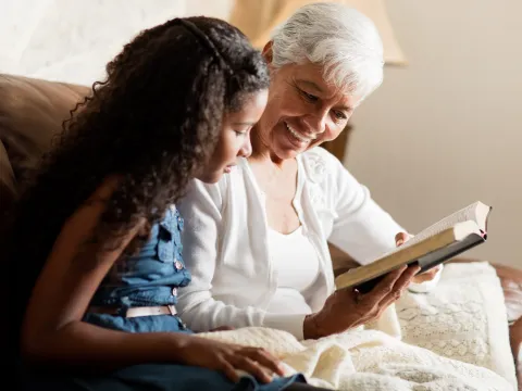 A grandmother and granddaughter read the Bible together.