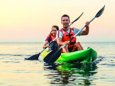 A couple kayaking on calm waters.