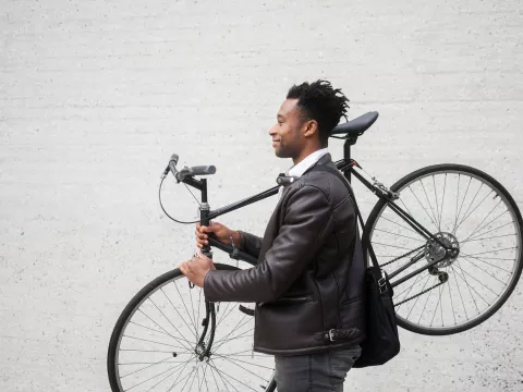 A man carries his bike after riding to work