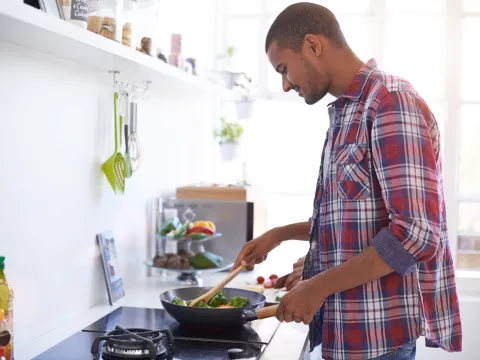 A man cooks a vegetable-based meal.