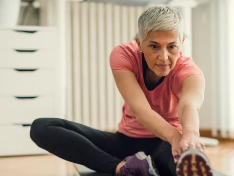 Older woman stretching to go for a run.