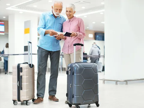 An older adult couple prepares to take a flight at the airport.