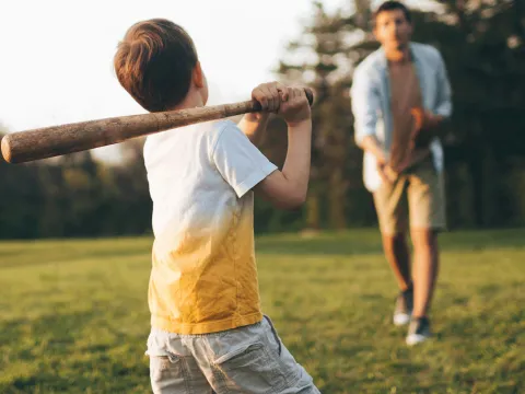 Father and son playing baseball outside