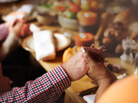 holding hands and praying at thanksgiving