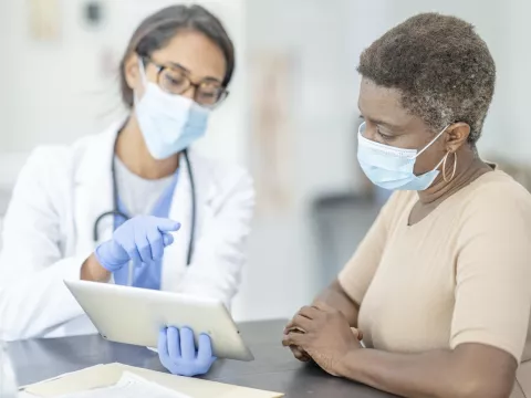A woman at the doctor wearing a mask.