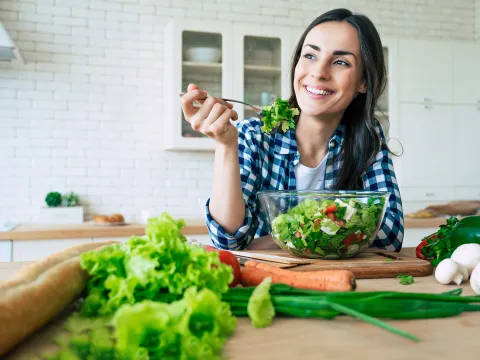 A woman eating a healthy, homemade salad. 