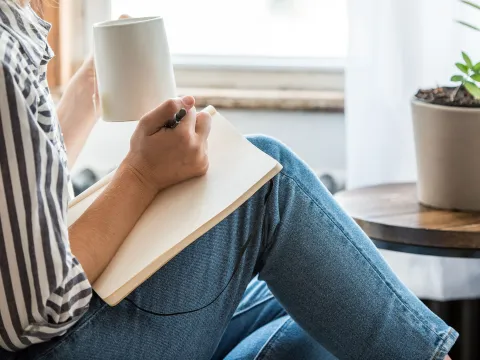 A woman indoors and journaling