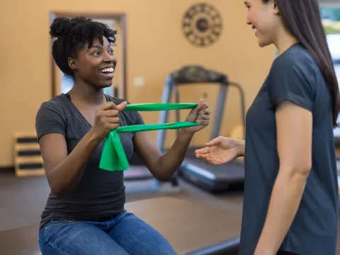 A woman does strengthening exercises with her physical therapist.