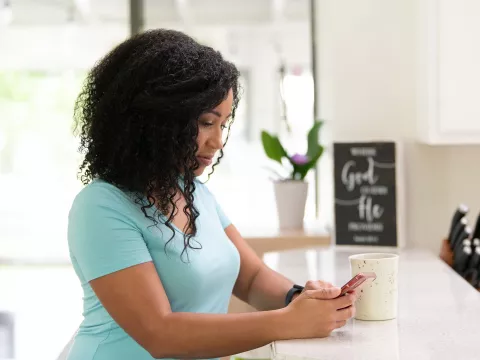 Woman at home on phone side profile serious