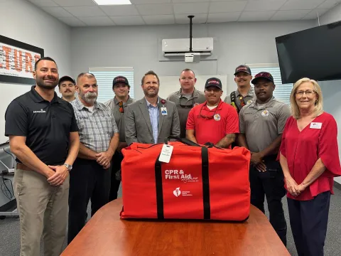 Davenport Firefighters, AdventHealth Heart of Florida and American Heart Association leaders pose with CPR and First Aid Kit
