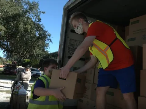 Volunteers unload a truck of food at the Hope Center