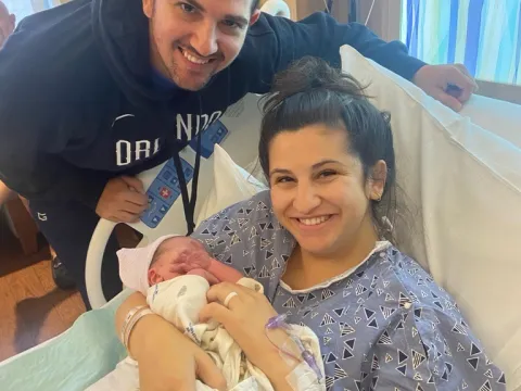 Photo of mom in the hospital holding her baby next to the dad