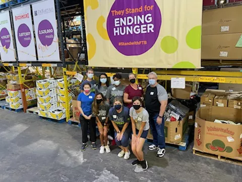 A group of volunteers in front of boxes of donated food