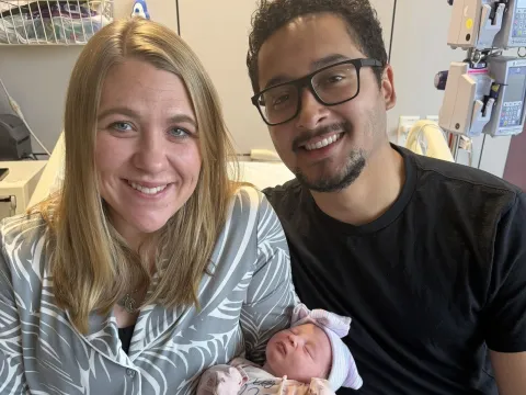 Baby Eliza with her mother and father in a hospital room.