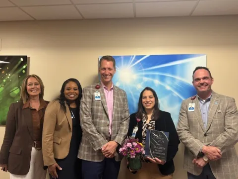 Team photo with woman holding an award