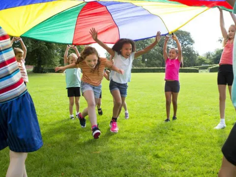 children-playing-outdoors-as-they-run-under-a-colorful-tent