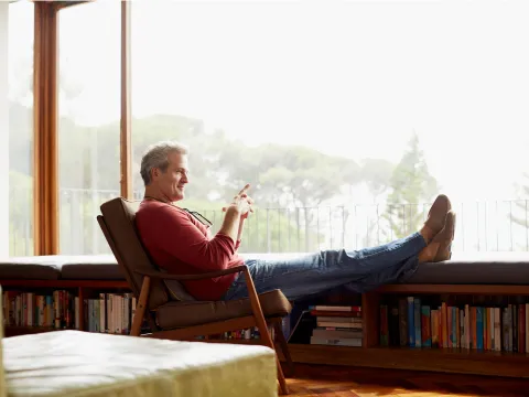 A man sits by a window at home