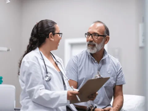 A middle-aged man talking to a female doctor.