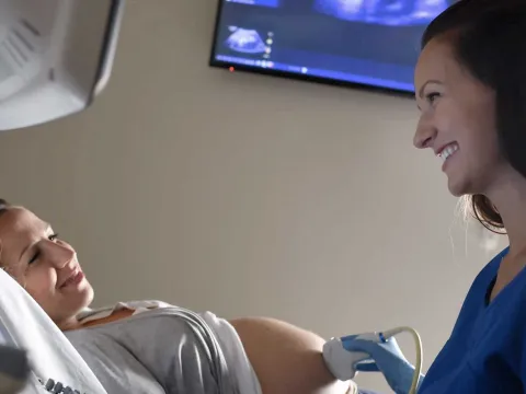 A nurse using an ultrasound on a pregnant mother