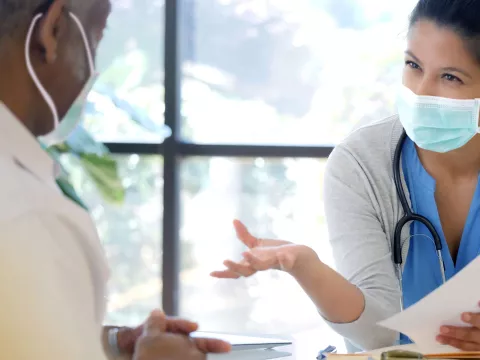 An older person speaking with his doctor. 