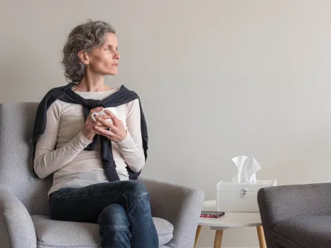 An older woman grieving at home. 