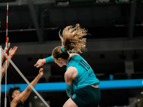 Orlando Valkyries player hits a ball over the net