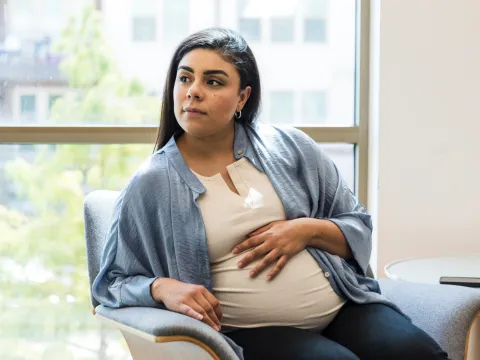 A pregnant woman sitting in a chair.