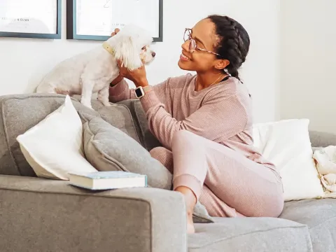 A woman playing with her dog.