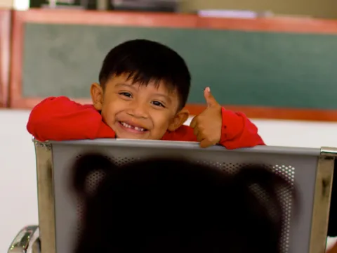 Child smiling in a classroom
