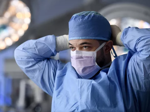 Surgeon putting on a face mask