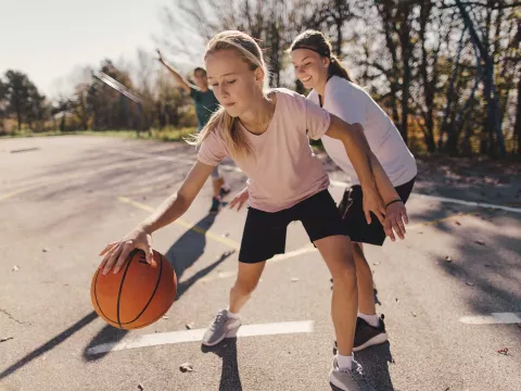 Young Girl Plays Basketball with Her Family