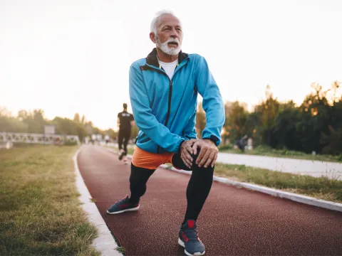 An older man stretching before a run.