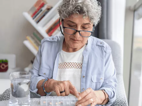 An older woman checking her medication.