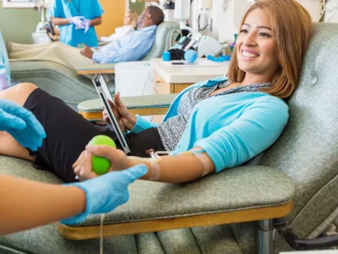 Smiling woman donates blood