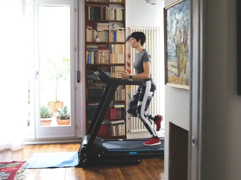 A woman running on the treadmill at home.
