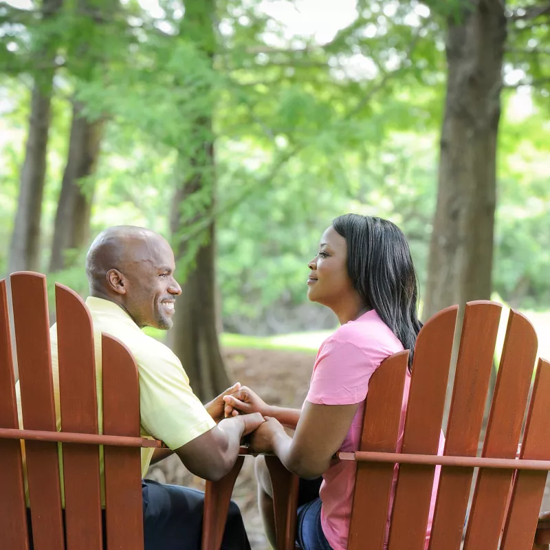 Couple Holding Hands And Sitting Together.