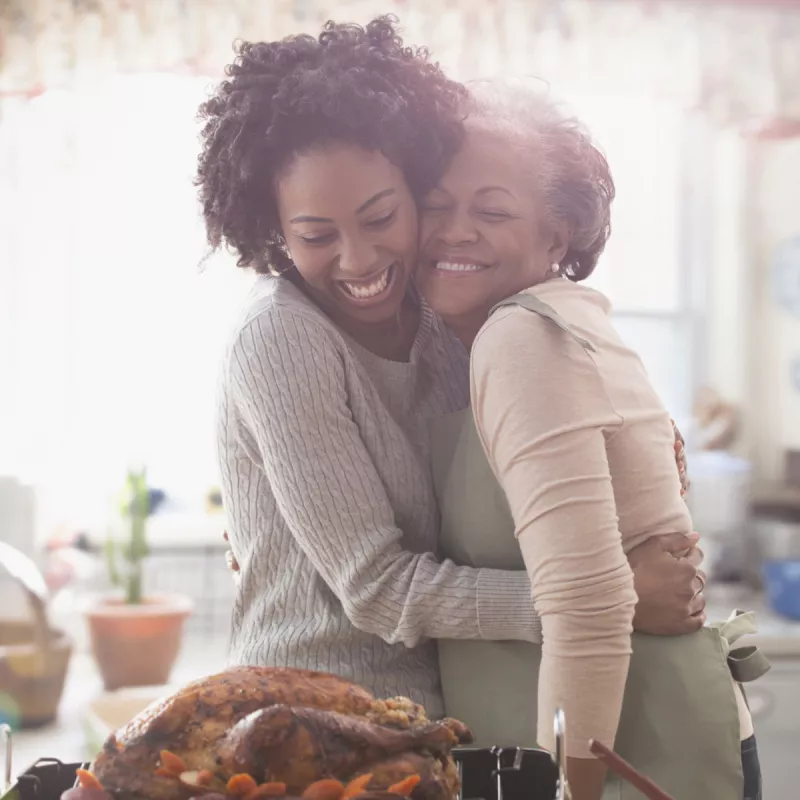 Mother and duaghter embracing in the kitchen filled with happiness