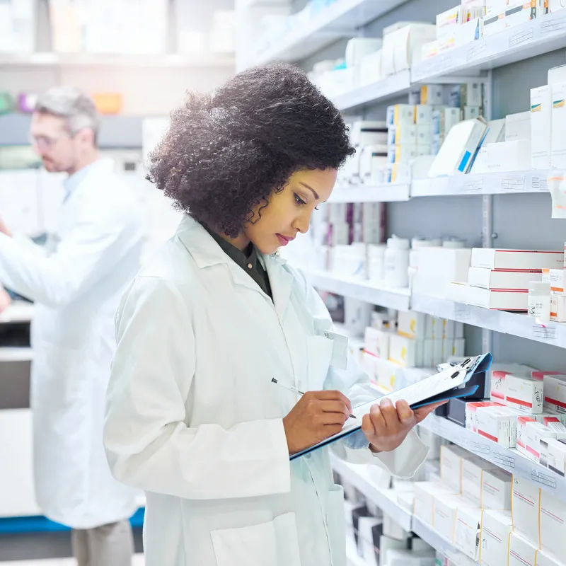 Female and male pharmacist working in an aisle in a pharmacy.
