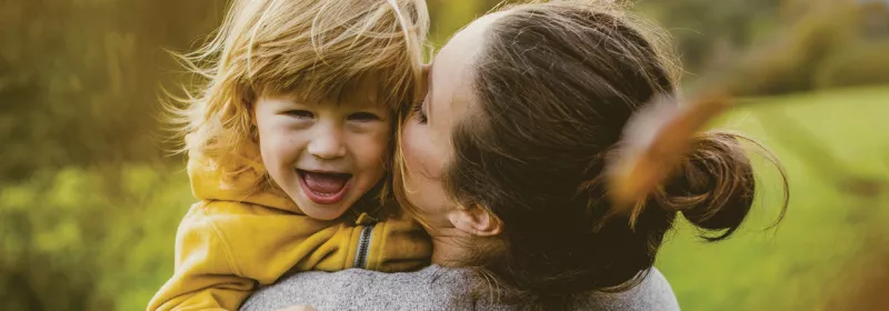 Mother holding smiling daughter