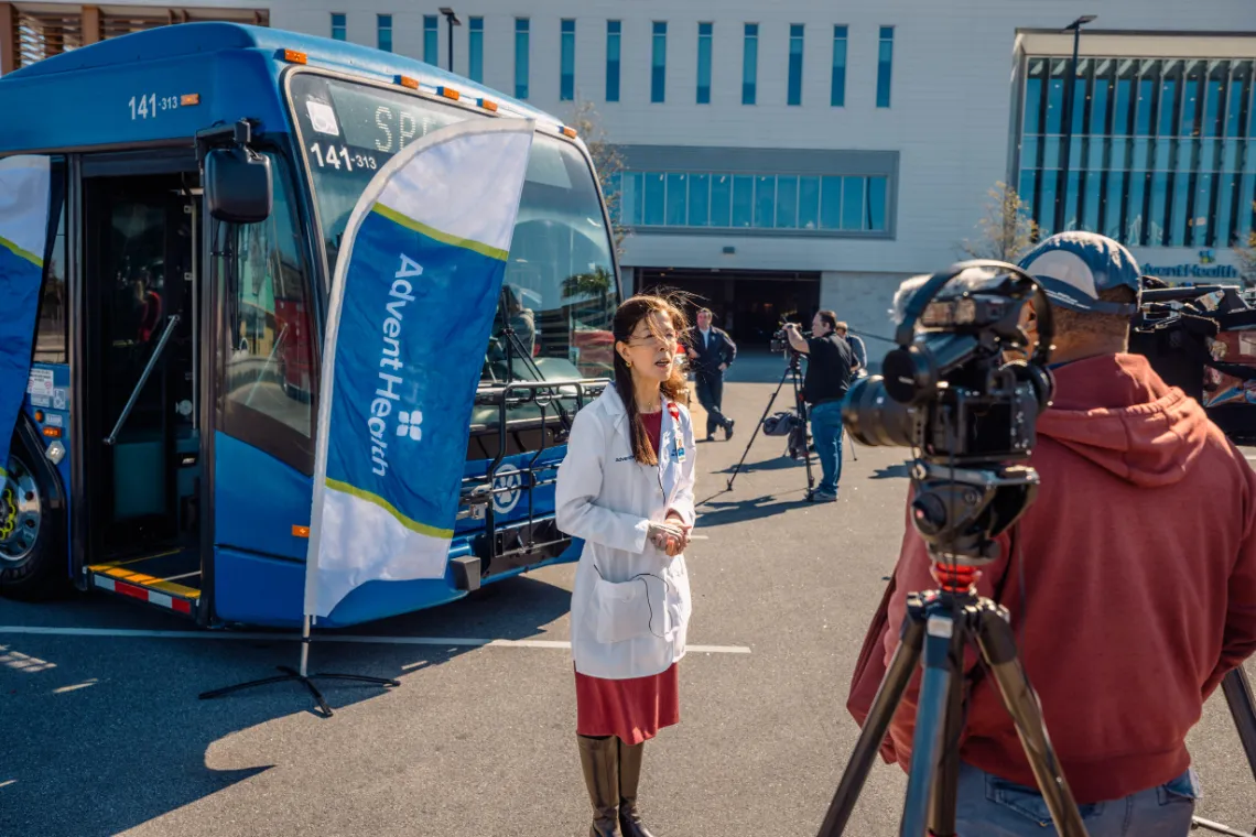 AdventHealth's Dr. Patricia Guerrero gives an interview in front of a newly AED-equipped LYNX LYMMO bus.