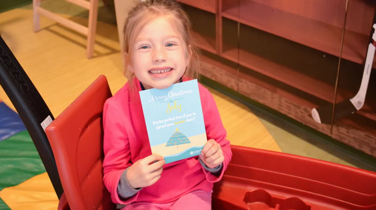 A child enjoys a Christmas in July celebration.