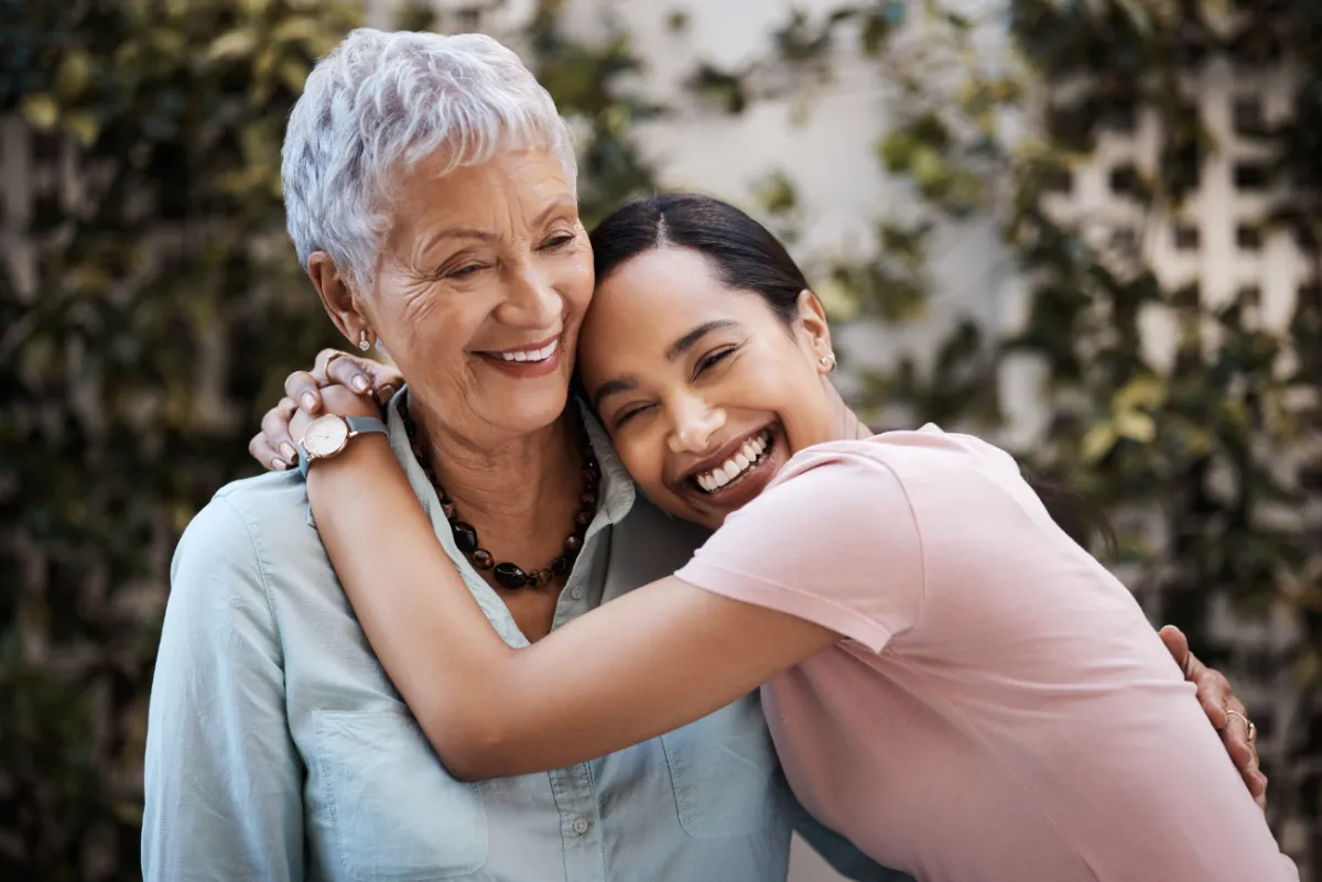 Two Hispanic women hug.