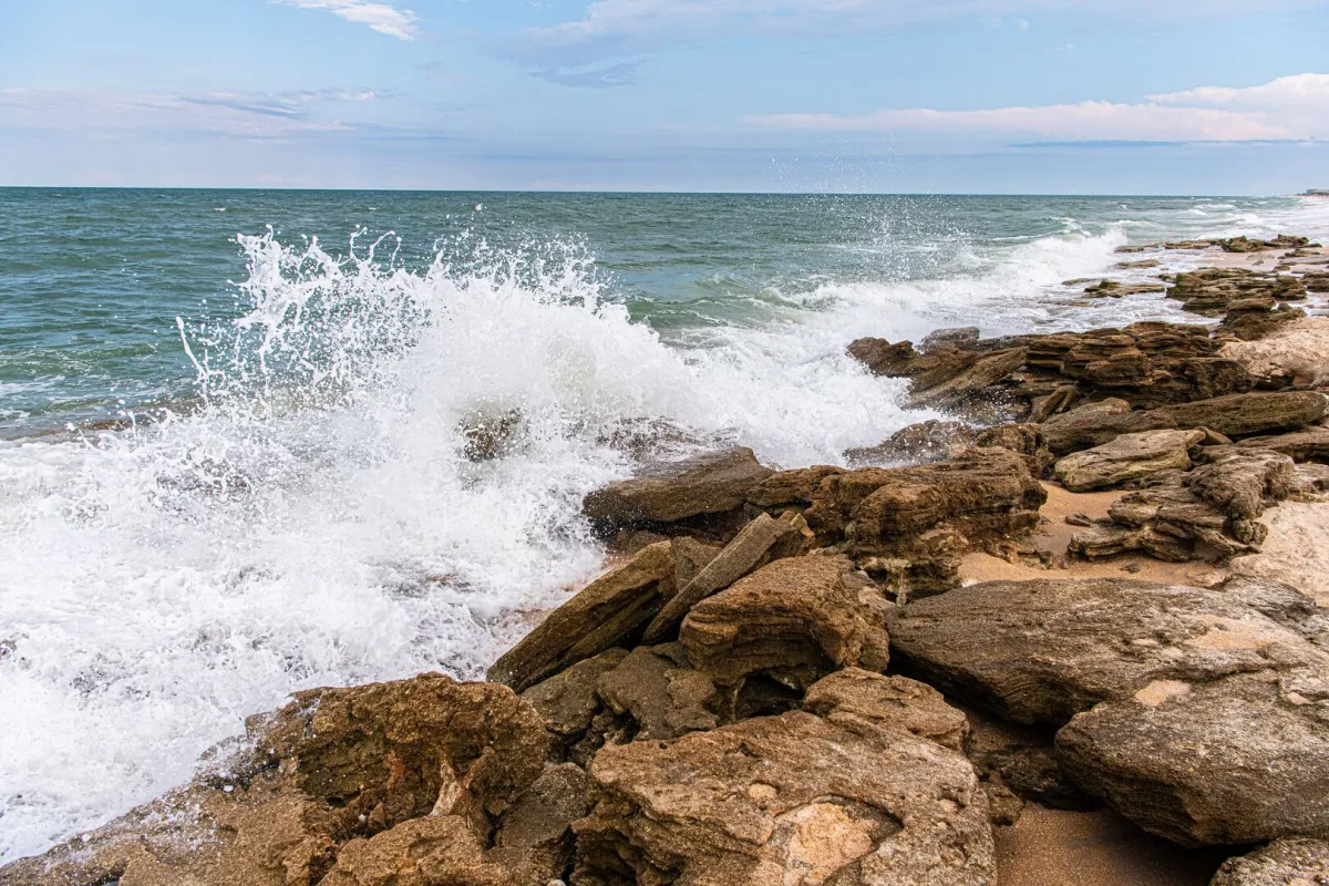 A wave smashes against rocks at Washington Oaks Gardens State Park in Palm Coast, Florida.