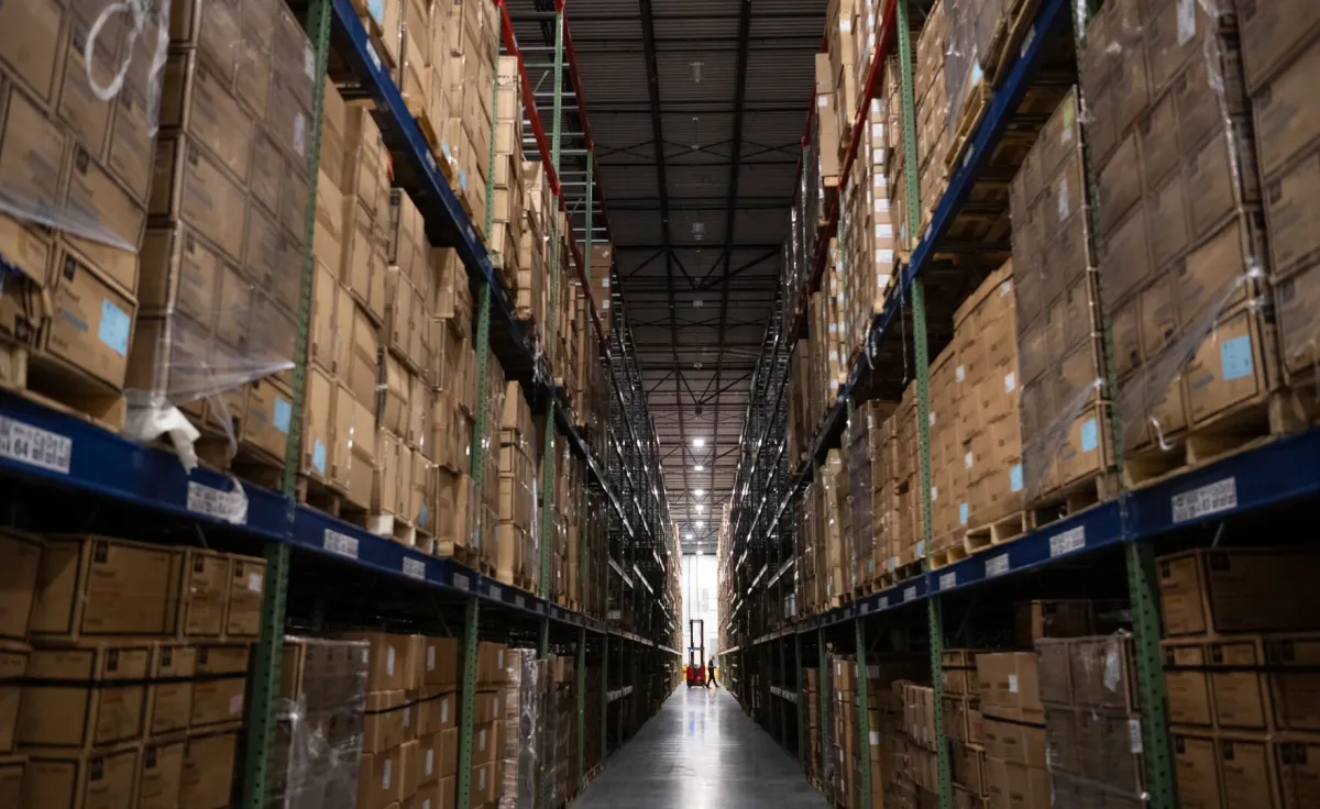 Boxes sit on shelves in a warehouse.