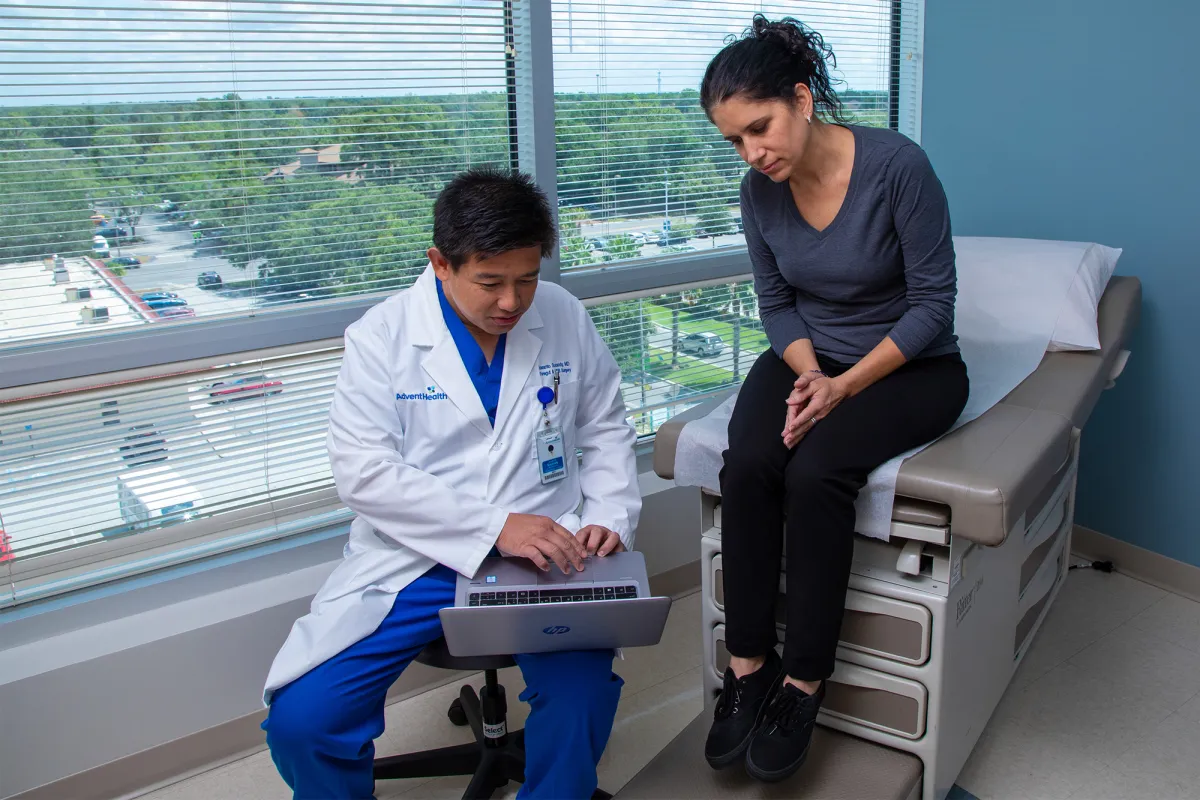 Dr. Iswanto Sucandy showing patient a something on a laptop.