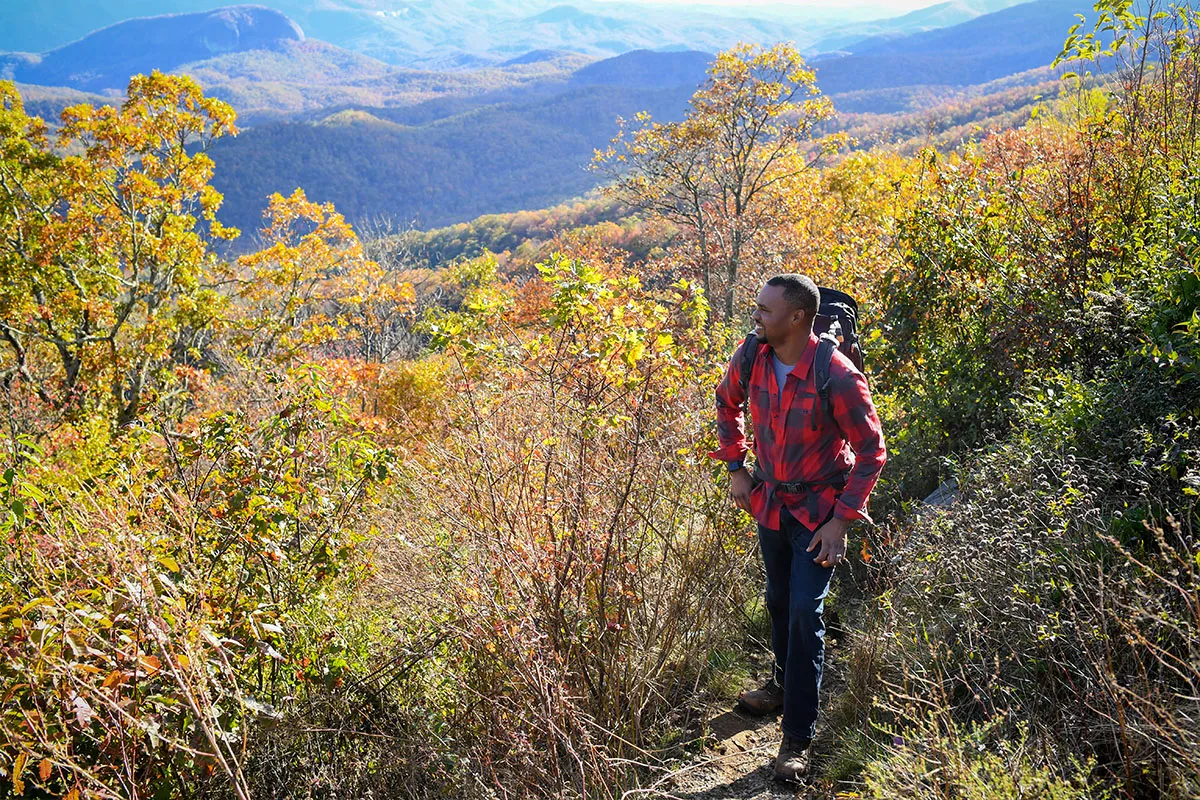 Man hiking around trees.